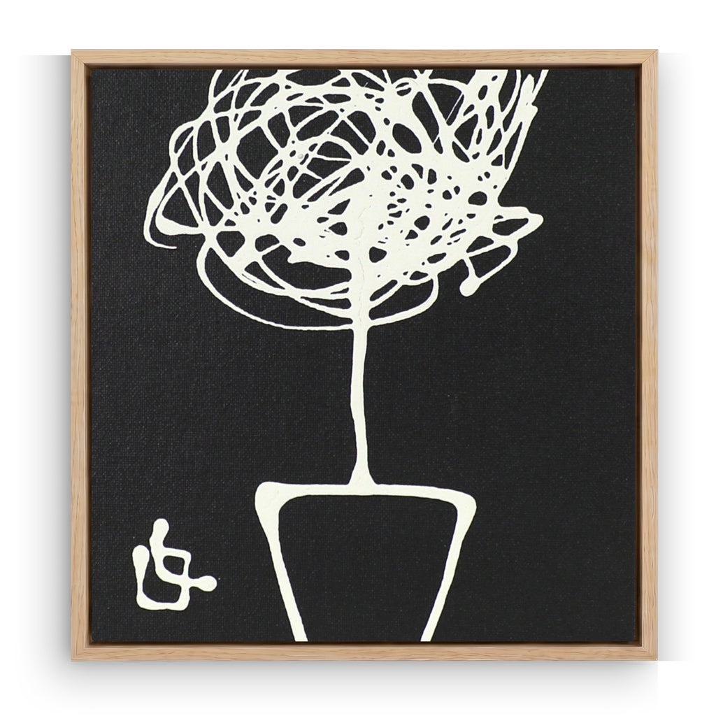 Framed black and white abstract artwork of a plant on a plain background
